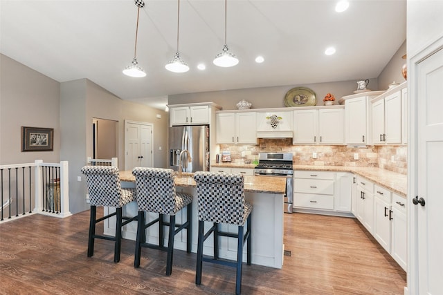 2006 NE 16th St, Ankeny, IA 50021 - kitchen with white cabinets, wood finished floors, tasteful backsplash, and stainless steel appliances