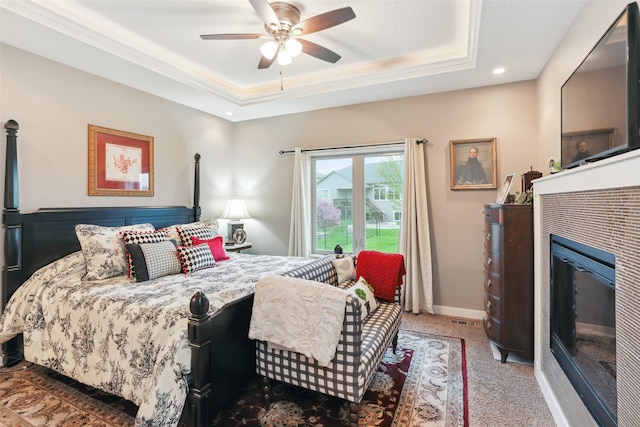 2006 NE 16th St, Ankeny, IA 50021 - bedroom with ornamental molding, a glass covered fireplace, ceiling fan, a raised ceiling, and carpet flooring