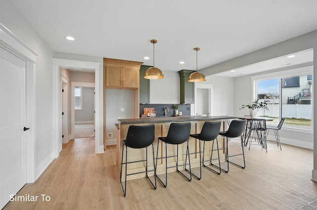 7325 NW Beaver Dr, Johnston, IA 50131 - kitchen with light wood-type flooring, recessed lighting, baseboards, and dark countertops