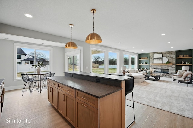 7325 NW Beaver Dr, Johnston, IA 50131 - kitchen featuring a kitchen breakfast bar, dark countertops, a wealth of natural light, and light wood-style flooring