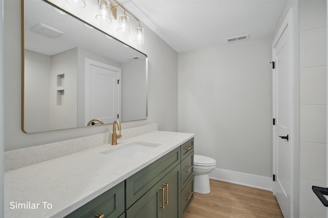7325 NW Beaver Dr, Johnston, IA 50131 - bathroom featuring vanity, toilet, baseboards, wood finished floors, and visible vents