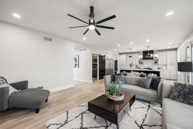 living room with visible vents, a barn door, ceiling fan, and recessed lighting