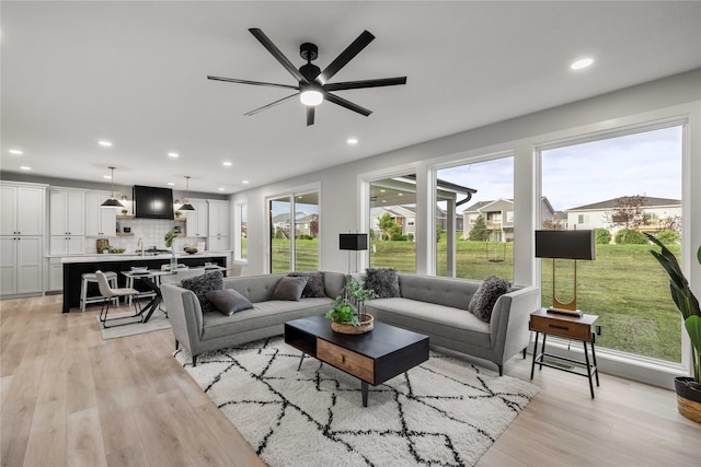 living area with recessed lighting, ceiling fan, and light wood-type flooring