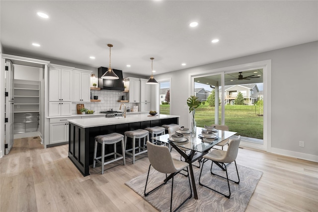 dining room featuring light wood-type flooring, a ceiling fan, baseboards, and recessed lighting
