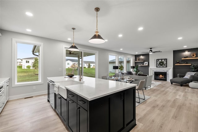 kitchen with dark cabinetry, a ceiling fan, recessed lighting, and a sink