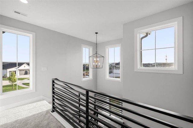 stairway featuring visible vents, recessed lighting, and a notable chandelier