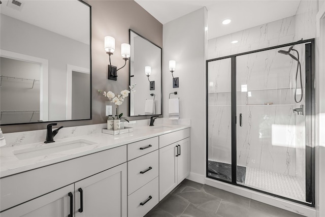 full bath with a sink, a marble finish shower, marble finish floor, and visible vents