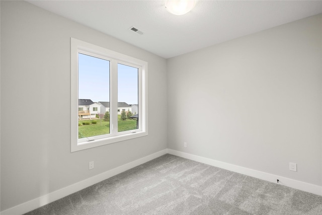 spare room with baseboards, carpet, and visible vents