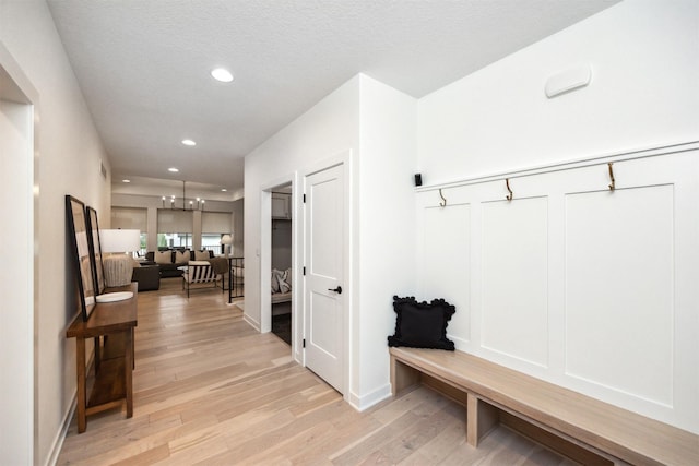 mudroom with recessed lighting, light wood-style flooring, and a chandelier