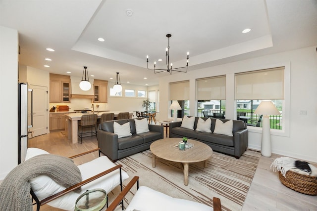 living room featuring light wood-style floors, a tray ceiling, and recessed lighting