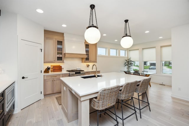 kitchen with plenty of natural light, a sink, gas range, and light countertops