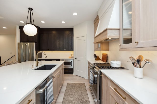 kitchen featuring a sink, custom exhaust hood, stainless steel appliances, recessed lighting, and pendant lighting