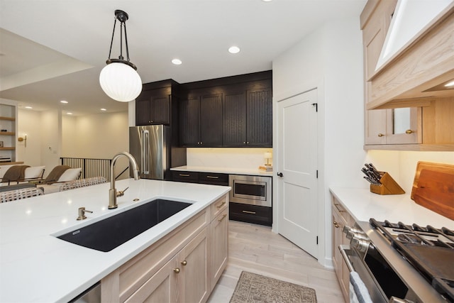 kitchen with hanging light fixtures, a sink, custom exhaust hood, stainless steel appliances, and recessed lighting