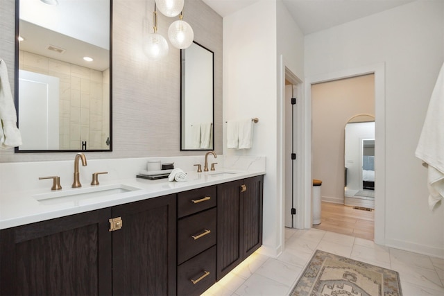 full bathroom featuring double vanity, a sink, connected bathroom, and marble finish floor
