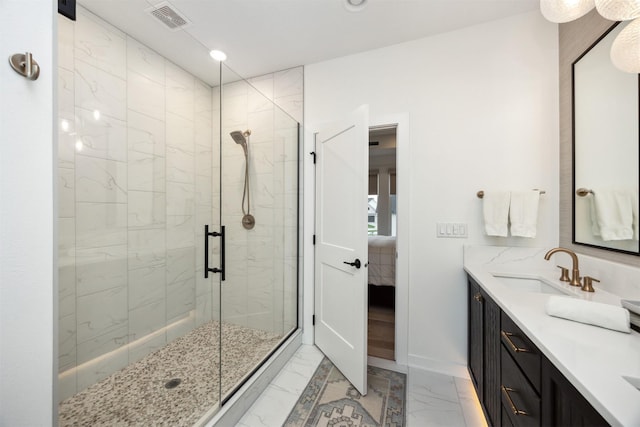 ensuite bathroom with visible vents, a stall shower, a sink, marble finish floor, and ensuite bath