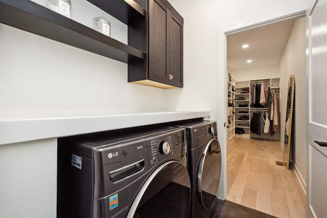 laundry area with recessed lighting, separate washer and dryer, light wood finished floors, and cabinet space