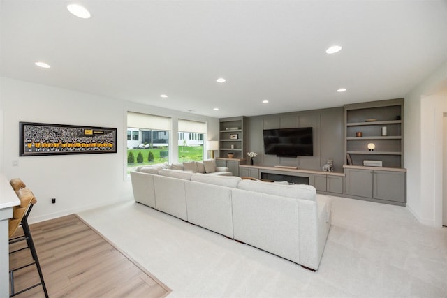 living area with recessed lighting, baseboards, built in features, and wood finished floors