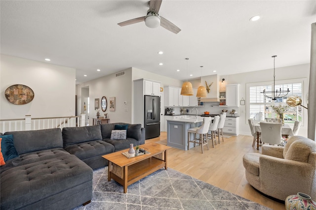 3319 NE 8th St, Ankeny, IA 50021 - living area with visible vents, recessed lighting, light wood-style floors, and ceiling fan with notable chandelier