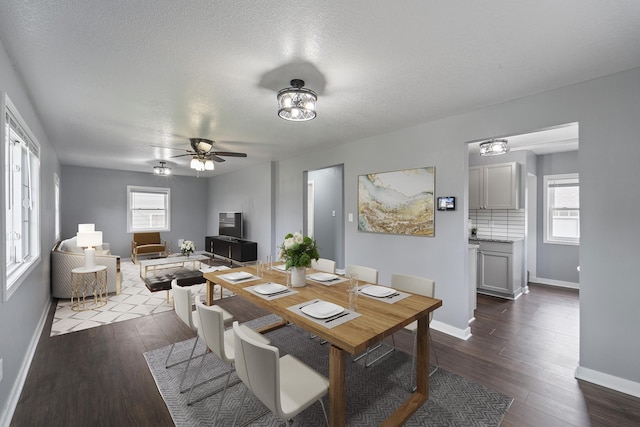 dining space with baseboards, a ceiling fan, a textured ceiling, and dark wood-type flooring