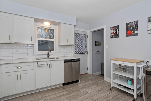 3924 55th St, Des Moines, IA 50310 - kitchen with stainless steel dishwasher, a sink, light countertops, and tasteful backsplash