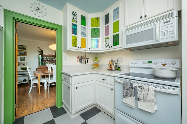 kitchen with light countertops, white cabinets, white appliances, and glass insert cabinets
