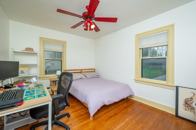 bedroom with a ceiling fan, baseboards, and hardwood / wood-style floors