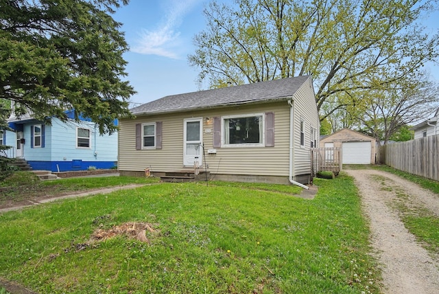 4131 Cornell St, Des Moines, IA 50313 - bungalow-style house with fence, a front lawn, a detached garage, dirt driveway, and an outdoor structure