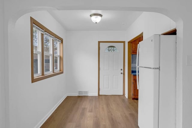 4038 57th St, Des Moines, IA 50310 - hallway with arched walkways, baseboards, light wood-type flooring, and visible vents