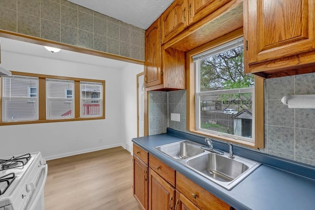4038 57th St, Des Moines, IA 50310 - kitchen with brown cabinets, a sink, and light wood finished floors