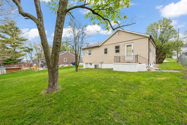 4038 57th St, Des Moines, IA 50310 - rear view of property with fence, central AC unit, and a lawn