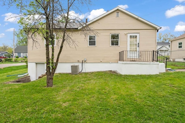 4038 57th St, Des Moines, IA 50310 - back of house featuring central air condition unit and a yard