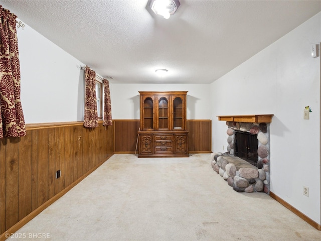 4508 SE 3rd St, Des Moines, IA 50315 - living area with a textured ceiling, a fireplace, wainscoting, wood walls, and light carpet