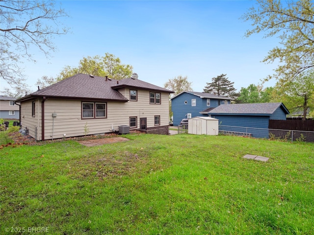 4508 SE 3rd St, Des Moines, IA 50315 - rear view of property with a storage unit, an outdoor structure, a lawn, and fence