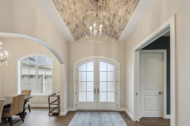 doorway to outside with arched walkways, a chandelier, french doors, and lofted ceiling
