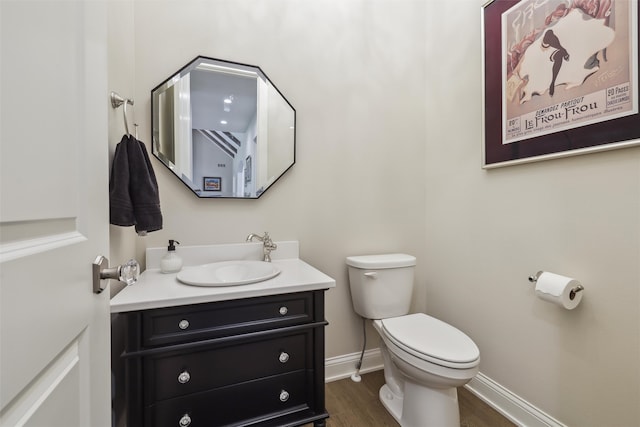 73 Myles Ct, Waukee, IA 50263 - half bath featuring vanity, toilet, baseboards, and wood finished floors
