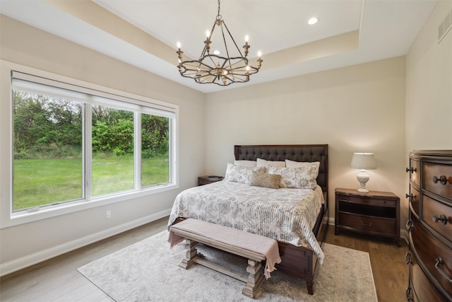 bedroom with baseboards, a chandelier, a tray ceiling, recessed lighting, and dark wood-type flooring