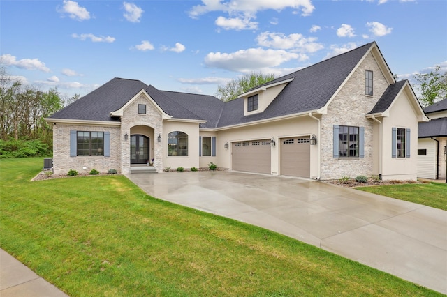 73 Myles Ct, Waukee, IA 50263 - view of front of home with driveway, an attached garage, stucco siding, roof with shingles, and a front lawn