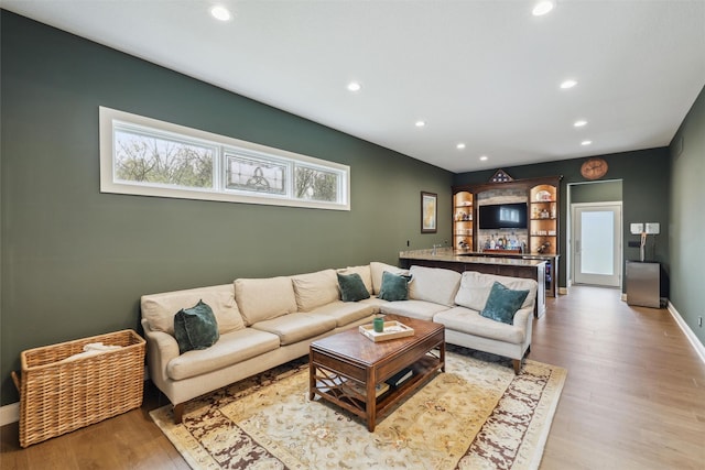 73 Myles Ct, Waukee, IA 50263 - living area featuring baseboards, light wood finished floors, recessed lighting, and bar