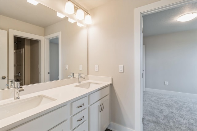 bathroom with double vanity, baseboards, and a sink