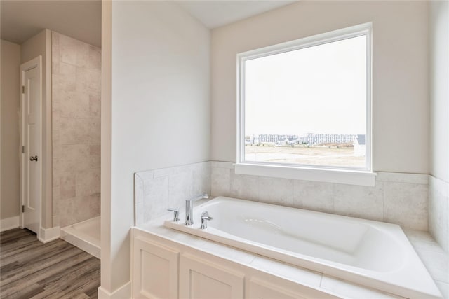 full bathroom with a garden tub, wood finished floors, and tiled shower