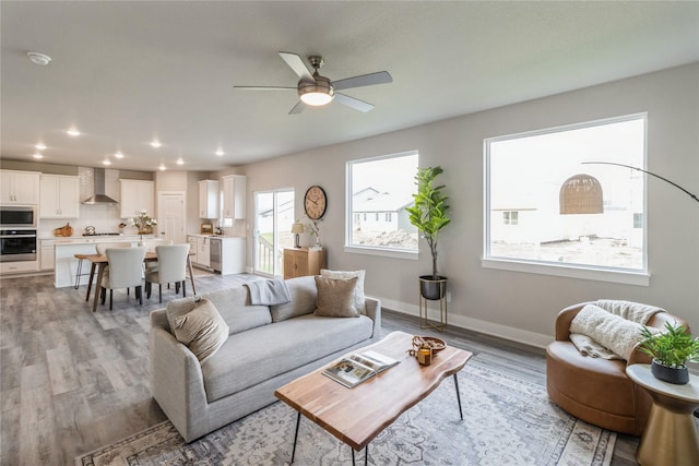 living room with recessed lighting, light wood finished floors, ceiling fan, and baseboards