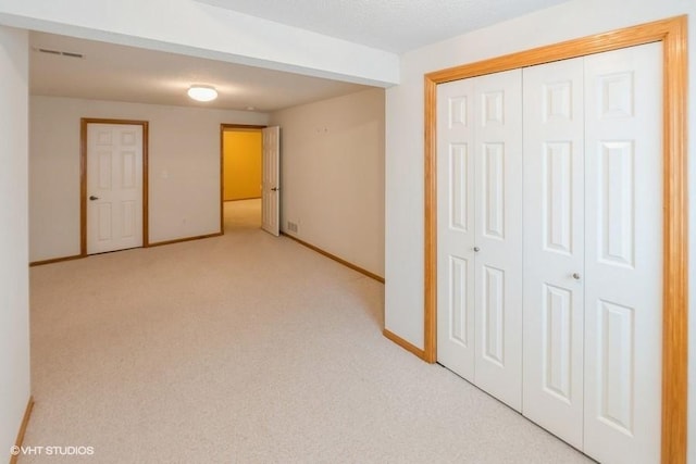 7422 SE 23rd St Unit 6, Des Moines, IA 50320 - unfurnished bedroom featuring baseboards, light carpet, a closet, and visible vents