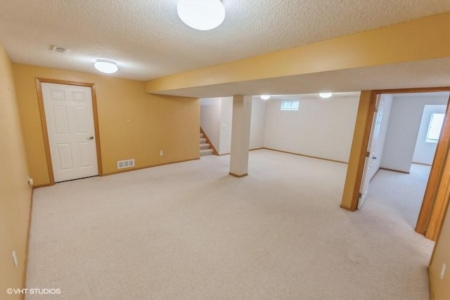 7422 SE 23rd St Unit 6, Des Moines, IA 50320 - below grade area featuring visible vents, carpet, a textured ceiling, and stairs