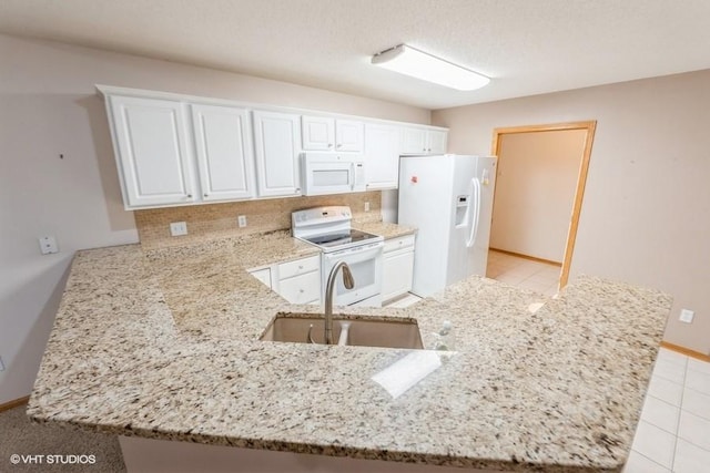 7422 SE 23rd St Unit 6, Des Moines, IA 50320 - kitchen featuring light stone countertops, a sink, white appliances, white cabinetry, and tasteful backsplash