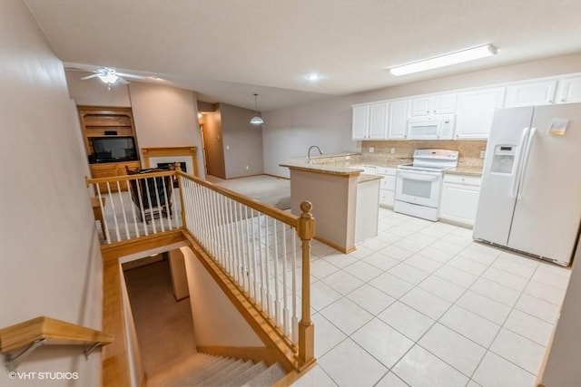 7422 SE 23rd St Unit 6, Des Moines, IA 50320 - kitchen with white appliances, white cabinetry, light stone countertops, and decorative light fixtures