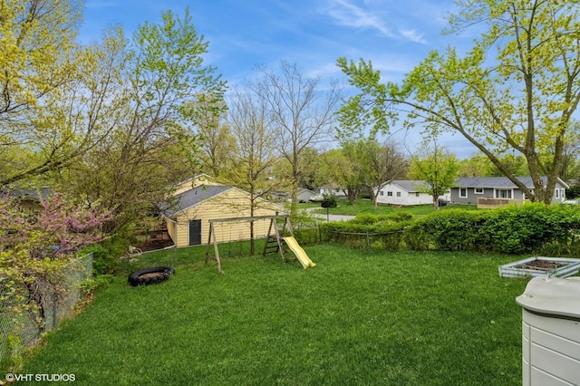 view of yard with fence, a playground, and a residential view