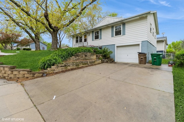 ranch-style house with driveway, a front yard, brick siding, fence, and an attached garage