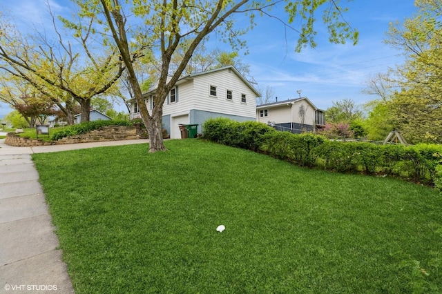 view of home's exterior featuring a lawn, an attached garage, and driveway