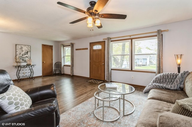 living room featuring baseboards, ceiling fan, and wood finished floors