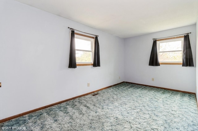 spare room featuring baseboards, carpet flooring, and visible vents